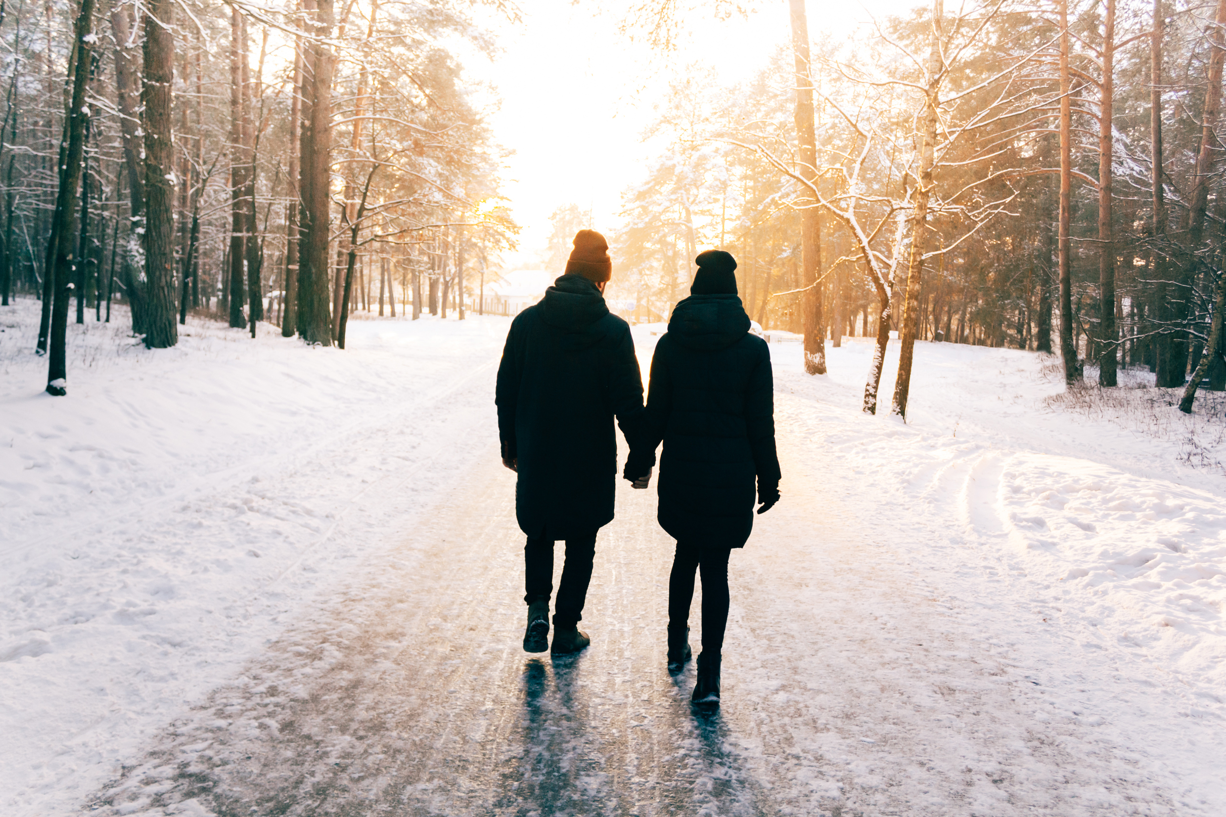 two people walking away holding hands